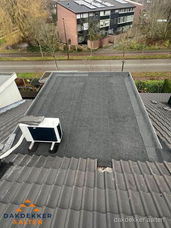 Plat dak inspectie met bitumen bedekking naast schuin pannendak in Aalten Plat dak inspectie met bitumen bedekking naast schuin pannendak in Aalten