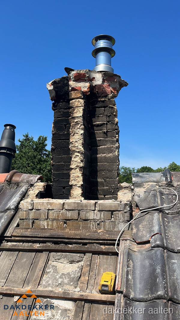 Beschadigde schoorsteen met nieuwe rookgasafvoer op oud dak in Aalten Beschadigde schoorsteen met nieuwe rookgasafvoer op oud dak in Aalten