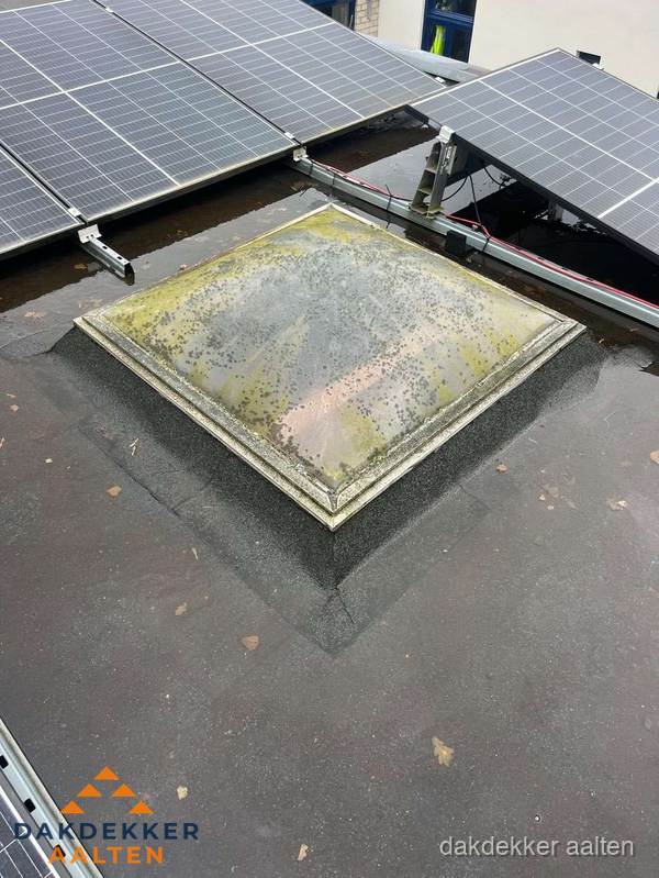 Vervuilde lichtkoepel op plat dak met zonnepanelen in Aalten Vervuilde lichtkoepel op plat dak met zonnepanelen in Aalten