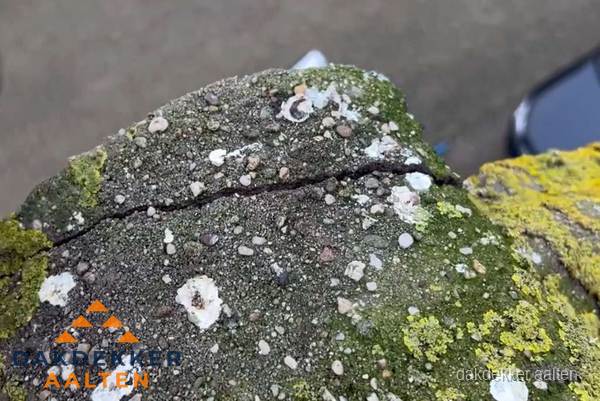 Beschadigde en verweerde nokvorst met scheuren en mos in Aalten Beschadigde en verweerde nokvorst met scheuren en mos in Aalten