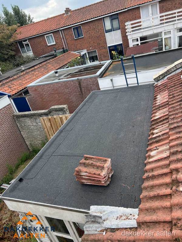 Plat dak aanbouw met bitumen naast schuin pannendak in Aalten Plat dak aanbouw met bitumen naast schuin pannendak in Aalten