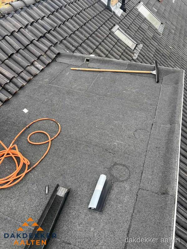 Plat dak reparatie met gereedschap en loodstroken in Aalten Plat dak reparatie met gereedschap en loodstroken in Aalten