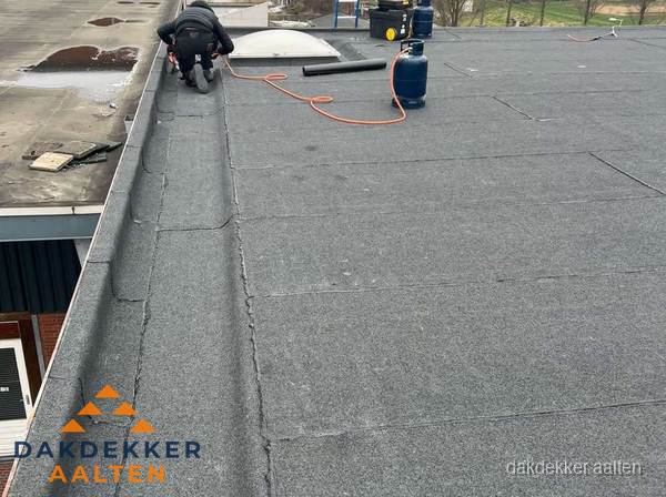 Dakdekker repareert bitumen dakbedekking op groot plat dak in Aalten Dakdekker repareert bitumen dakbedekking op groot plat dak in Aalten