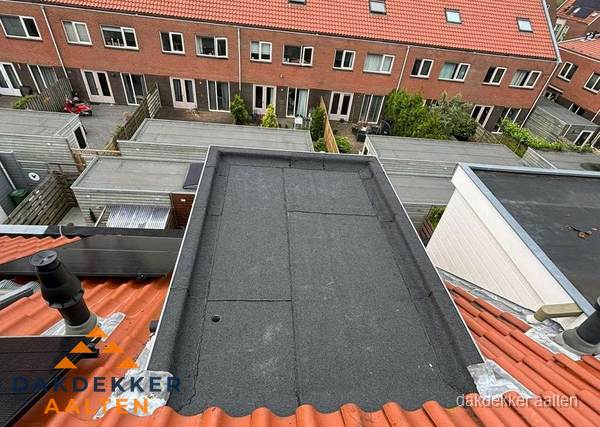 Plat dak met bitumen bedekking naast dakkapel in Aalten