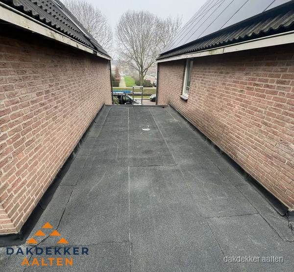 Plat dak met bitumen dakbedekking tussen bakstenen muren in Aalten Plat dak met bitumen dakbedekking tussen bakstenen muren in Aalten
