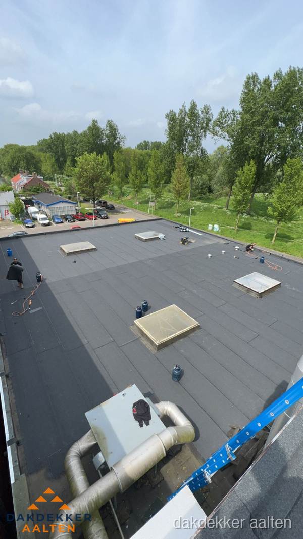 Dakdekker aan het werk op groot plat dak met bitumen in Aalten Dakdekker aan het werk op groot plat dak met bitumen in Aalten